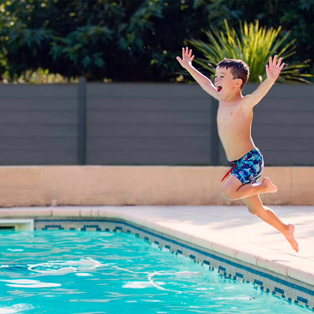 enfant qui saute dans une piscine et cloture composite neowood anthra