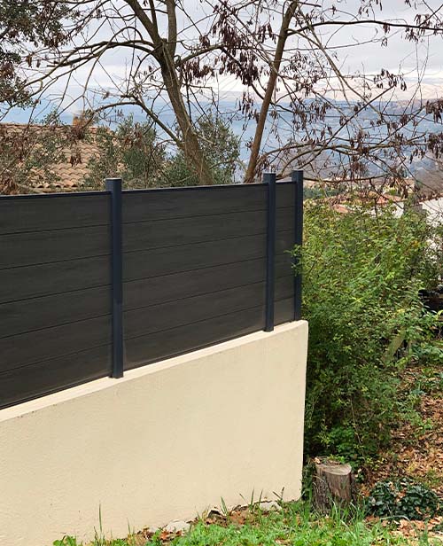 clôture composite neowood teinte anthra sur muret beige