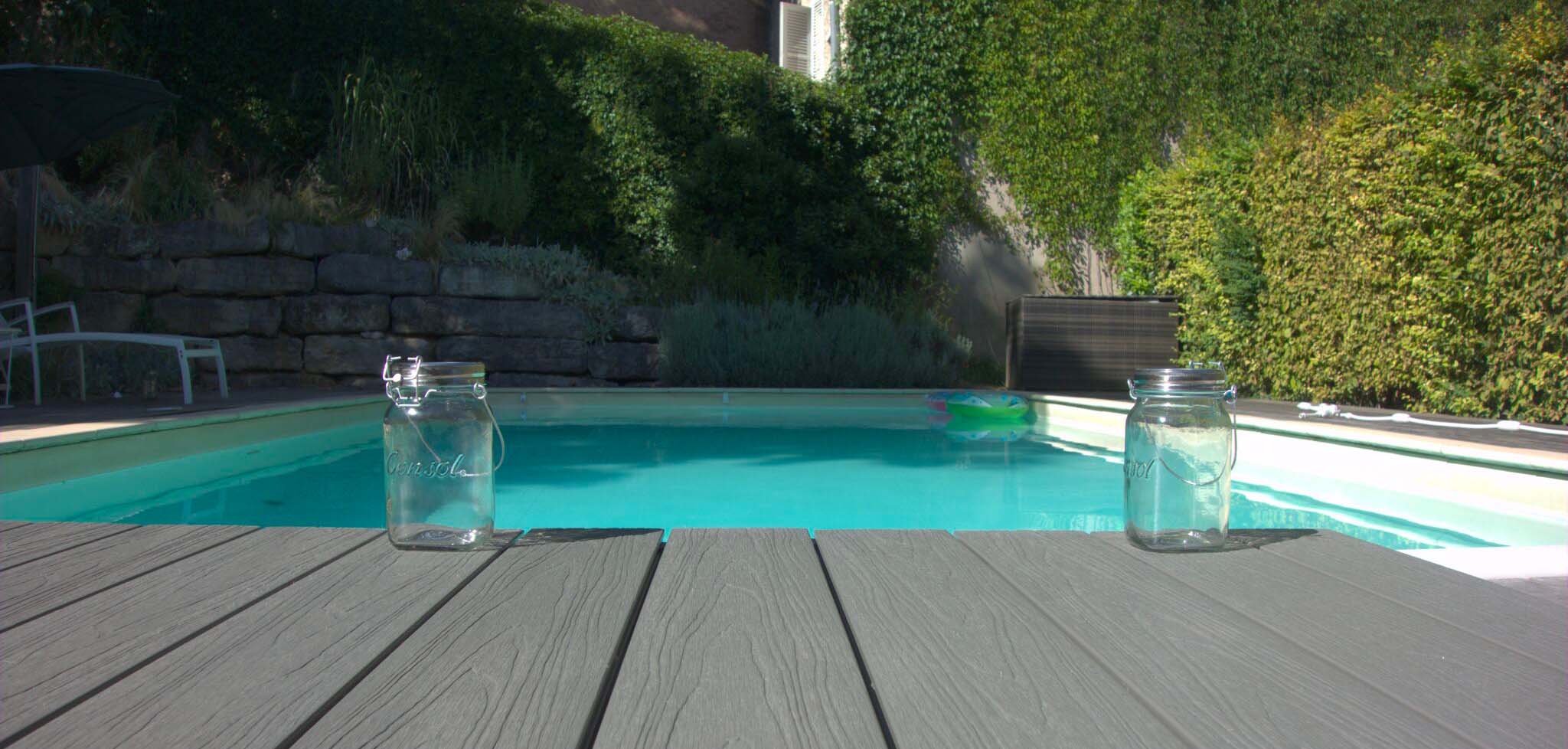 zoom lames de terrasse ultraprotect teinte béton et finitions structurées en bord de piscine